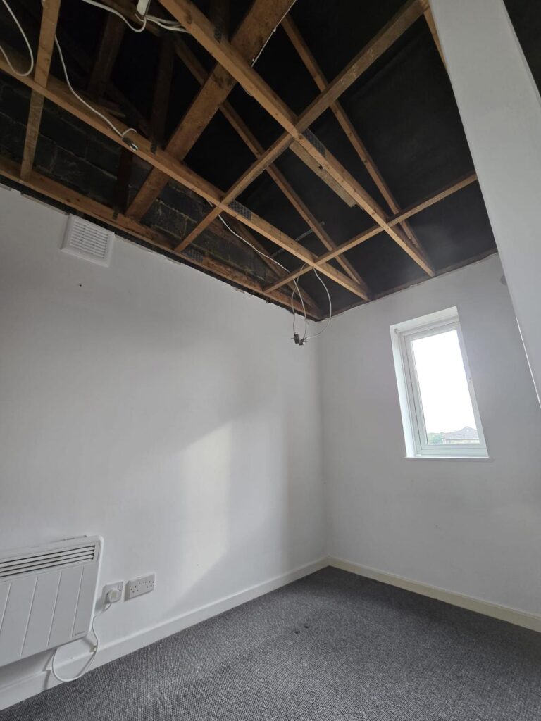 Empty room with ceiling stripped to joists for Artex removal