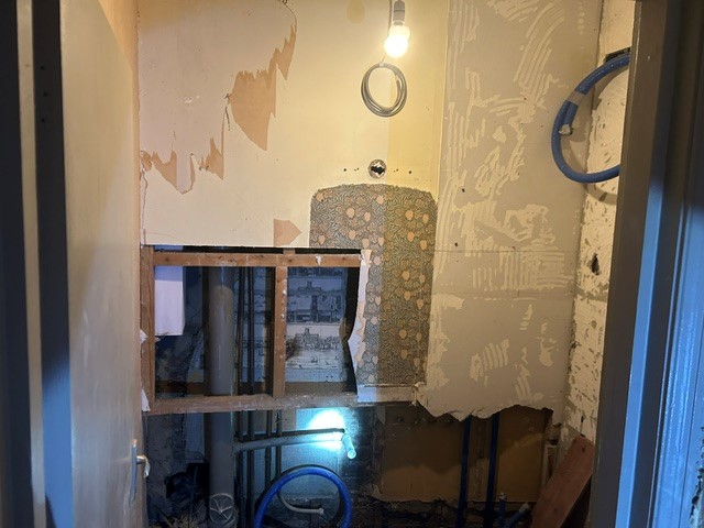 Damp-stained ceiling and wall in a property checked for asbestos after a building survey
